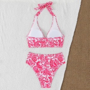 Detail of pink paisley bikini with halter neck ties and removable pads on textured rug