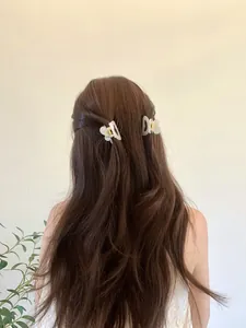 Détail de pinces à cheveux papillon blanc translucide portées sur une coiffure élégante