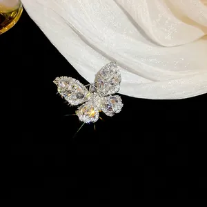 Elegant butterfly brooch with teardrop cubic zirconia on white silk background