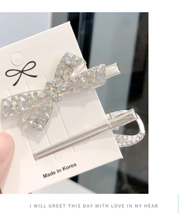 Close-up of a sparkling crystal bow hair clip with silver finish and Made in Korea label