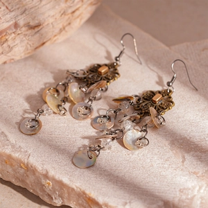 Detail of vintage bronze flower earrings with shimmering shell discs and beads