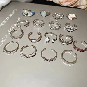 Mixed set of adjustable silver rings featuring zircon flowers, butterflies, and pearls