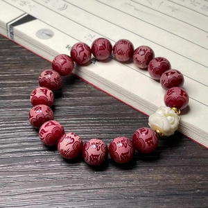 Traditional Chinese cat paw bracelet with white jade root carving and red beads on wood