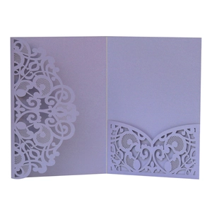Macro shot of laser-cut lace pattern on lavender pearlescent paper wedding invitation