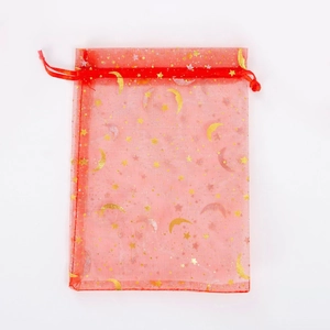 Macro view of red organza jewelry pouch with gold and silver star moon foil print