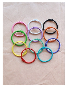 Macro shot of colorful coated metal split rings and book rings on textured background