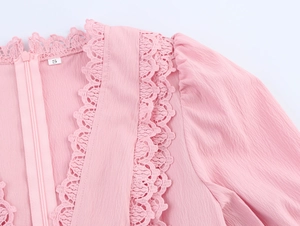 Detailed view of pink dress featuring lace trim, invisible back zipper and textured fabric