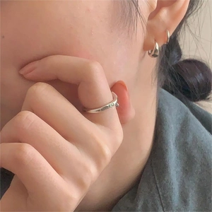 Detailed close-up of 925 sterling silver smile ring and earring set worn by model