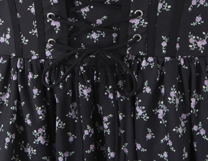 Close-up of floral print dress with purple flowers and black waist lace-up detail