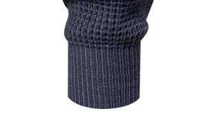 Detail of navy blue waffle knit sweater showing ribbed cuffs and high-quality fabric texture