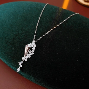 Macro detail of silver zircon hourglass pendant showing leaf design and sparkling stones