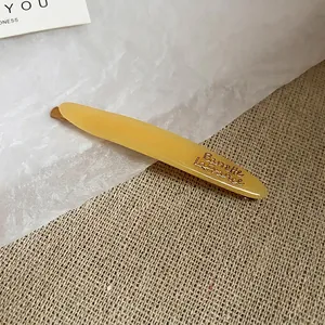 Elegante fermaglio per capelli in acrilico ambrato con scritte dorate su lino