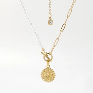 Détail d'un collier de perles avec fermoir OT doré et pendentif lettre J circulaire