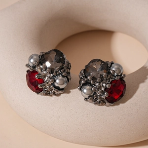 Macro detail of vintage cluster stud earrings with red and grey gemstones and dark pearls