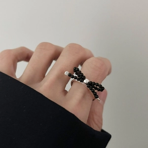 Minimalist 925 sterling silver bow ring with black beads on a model's hand