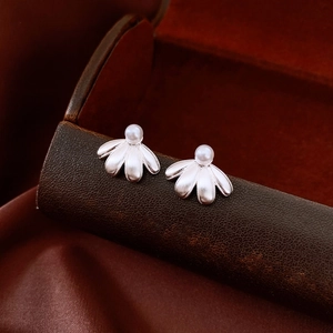 Macro shot of silver pearl flower earrings with brushed metal petals and vintage style