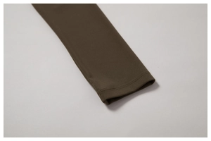 Detalle de los puños con costura de doble aguja en un top deportivo de yoga verde