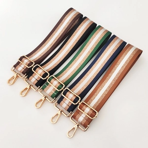 Detail showing five adjustable striped bag straps with premium gold metal hardware
