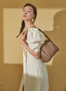 Close-up of brown lychee grain cowhide leather shoulder strap on a designer handbag