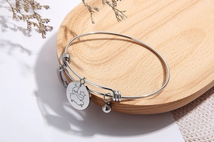 Detail of adjustable silver star and moon charms on a stainless steel bangle