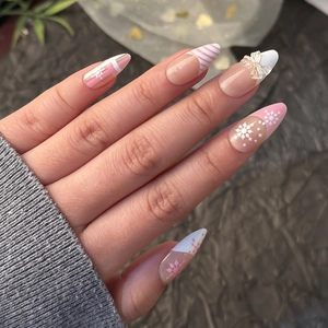 3D pink French press on nails with winter snowflake patterns and a cute 3D bow accent