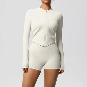Close-up of cream white yoga set with zip-up top featuring a V-shaped hem and high waist shorts
