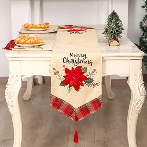Festive linen table runner with red poinsettia pattern and Merry Christmas text decor