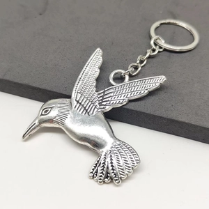Detailed view of hummingbird keychain with intricate feather textures on silver alloy metal