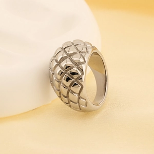 Close-up of a silver ring featuring a textured geometric grid pattern and industrial style