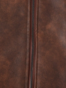 Détail de la texture en similicuir marron avec une fermeture éclair en métal noir robuste