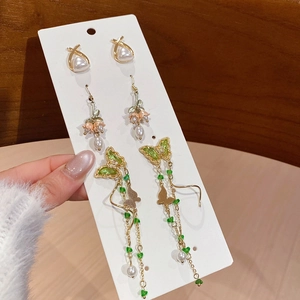 Detailed set of floral and butterfly pearl drop earrings on white display card