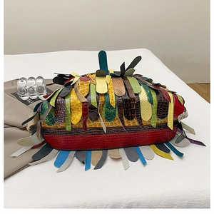 Detail of colorful patchwork leather tote with multi-texture patterns and long fringe accents