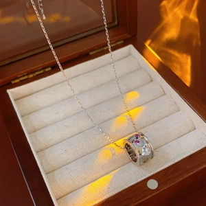 Dettaglio della collana con stelle in zircone in scatola di legno e luce calda