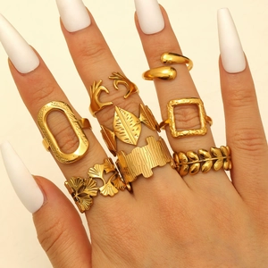 Set of eight gold stainless steel rings with heart and geometric leaf patterns