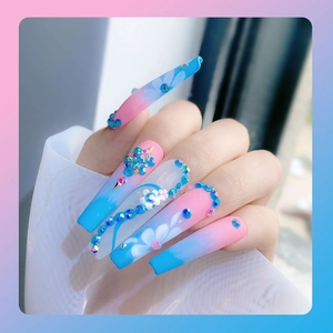 Macro detail van lange vierkante kunstnagels met roze-blauw verloop en bloemige strassteentjes