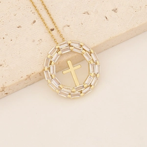Macro shot of 18K gold plated cross pendant with cubic zirconia stones on stone surface