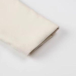 Detailed close-up of beige wool jacket cuff showing premium stitching and fabric texture