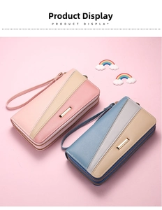 Dual-zipper long wallet with wristlet strap and metallic accent bar on pastel background