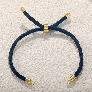 Detail of black Milan cord bracelet with adjustable gold-plated slider clasp and metal rings