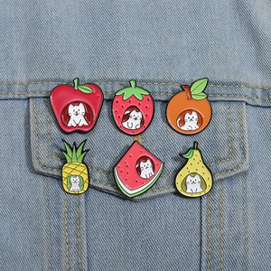 Set of 6 cute fruit-shaped cat enamel pins pinned on a denim jacket pocket fabric
