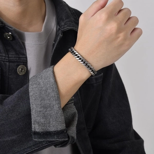 Close-up of silver stainless steel Cuban link bracelet worn on a man's wrist