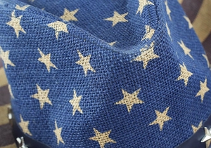 Détail d'un chapeau de cowboy bleu en paille avec étoiles et bandeau en cuir à clous argentés