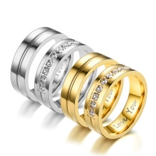 Detail of silver and gold couple rings with stone setting and 'I Love You' engraving