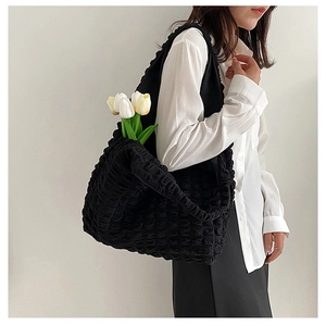 Detail view of black bubble quilted tote bag showing large capacity and soft texture