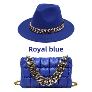 Detail of royal blue fedora hat with gold chain and matching quilted cloud handbag