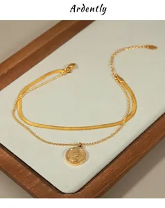 Close-up of gold double-layer necklace with snake chain and portrait coin pendant