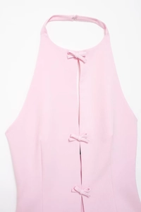 Detail eines rosa Neckholder-Tops mit drei Schleifen auf feiner Textilstruktur