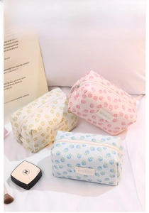 Detailed set of three floral lace cosmetic bags in pink, beige, and light blue colors