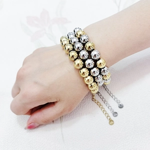 Detailed view of triple-layer gold and silver beaded bracelet with adjustable chain
