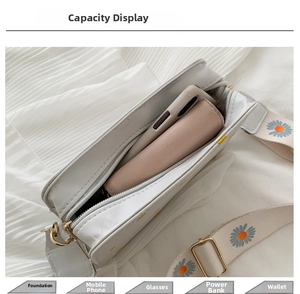 Detail view of white daisy floral bag showing capacity for phone, wallet and cosmetics